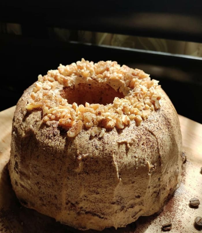 Bundt cake topped with walnuts and chocolate drizzle